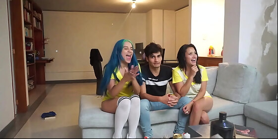 man watches a soccer game with two girls licking pussy next to him